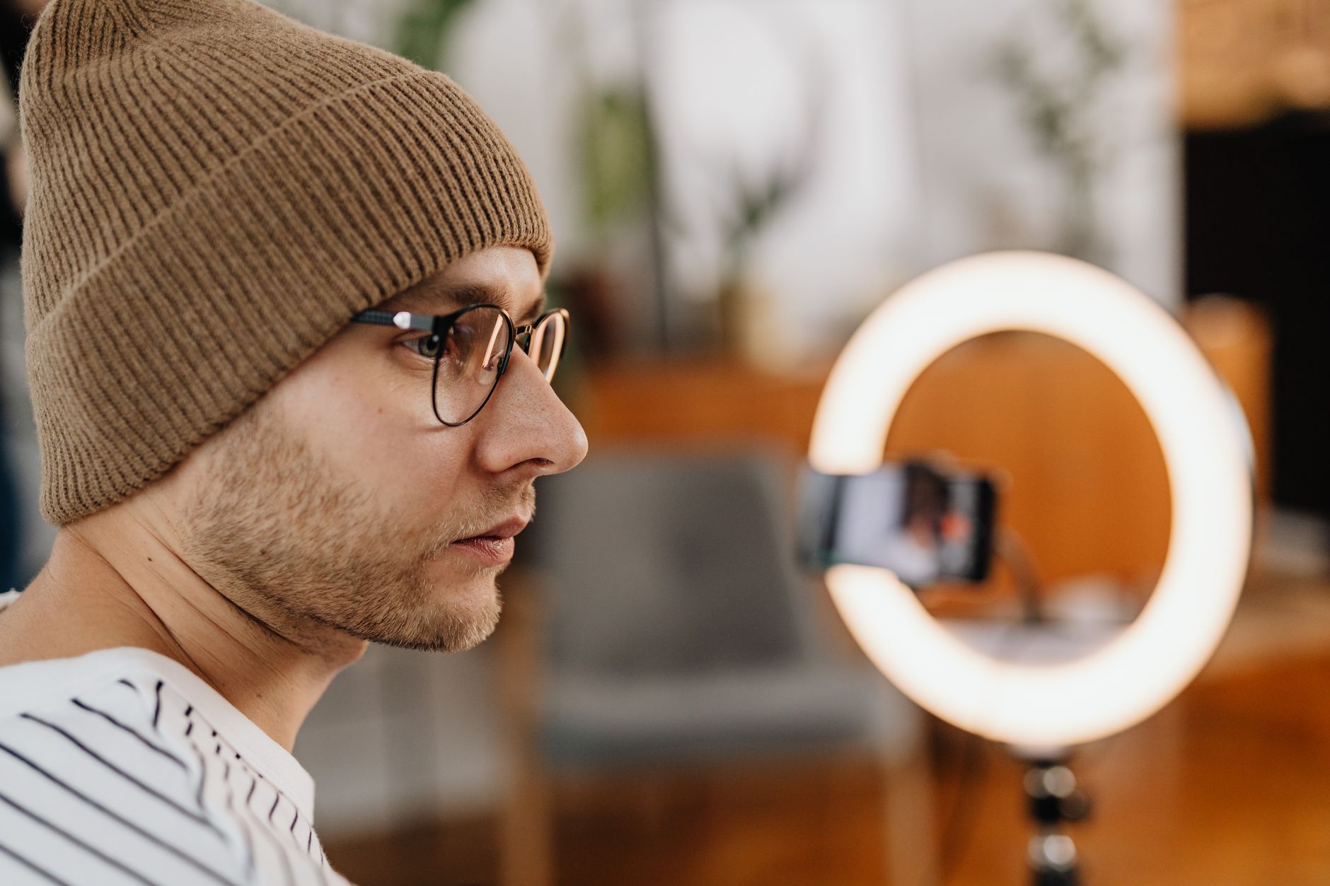 Content creator recording with smartphone and ring light for Instagram D2C brand marketing