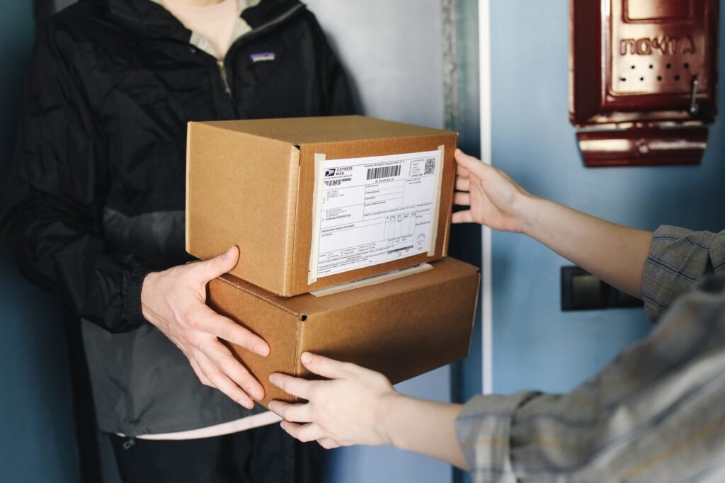 Quick commerce delivery person handing over parcel to customer in India