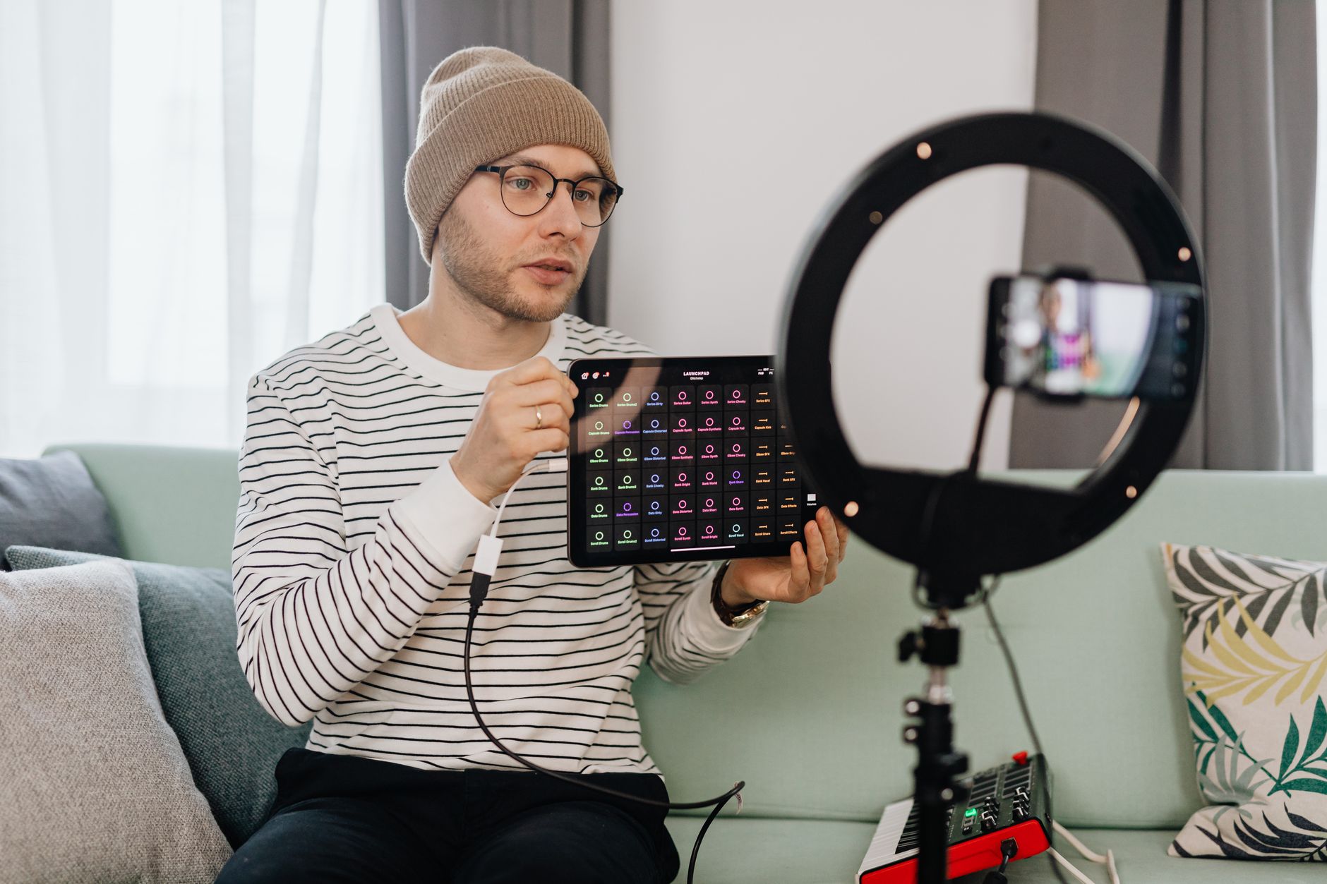 Content creator recording a product review video with smartphone and ring light